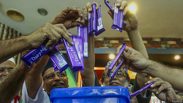 मलेशियाको थोक तथा खुद्रा व्यापारी एशोसिएसनका सदस्यहरु क्याडबरी चक्लेट नष्ट गर्दै । तस्वीर: रोयटर्स